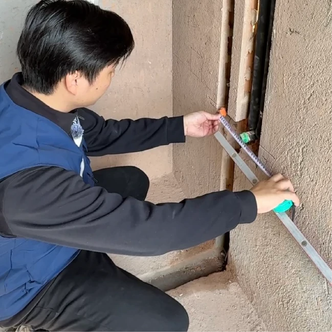 工程师在现场进行墙体尺寸测量勘查